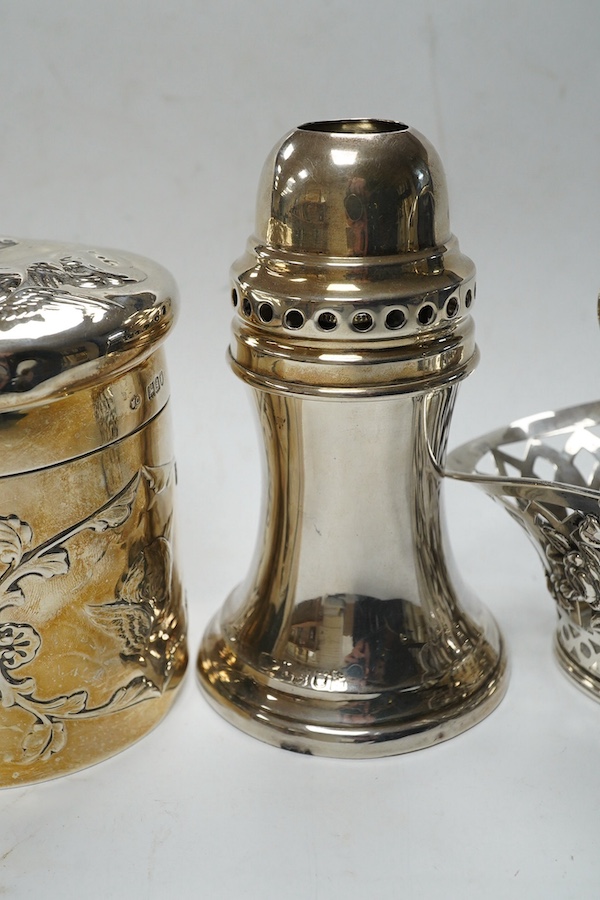 An Edwardian silver 'Reynold's Angels' silver canister, William Comyns, London, 1902, 90mm, together with a silver table perpetual lighter, silver bonbon basket and silver ring box. Condition - poor to fair